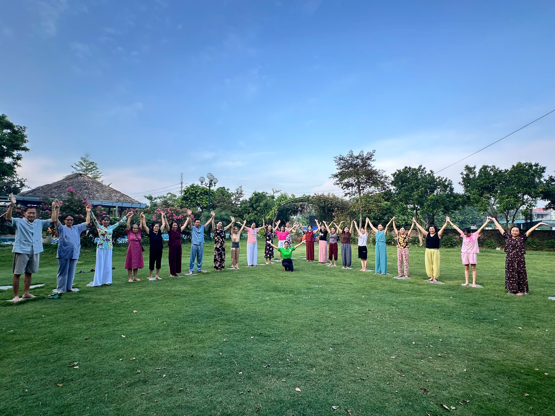 Học viên tập dưỡng sinh buổi sớm trên bãi cỏ xanh tại Mộc Villa